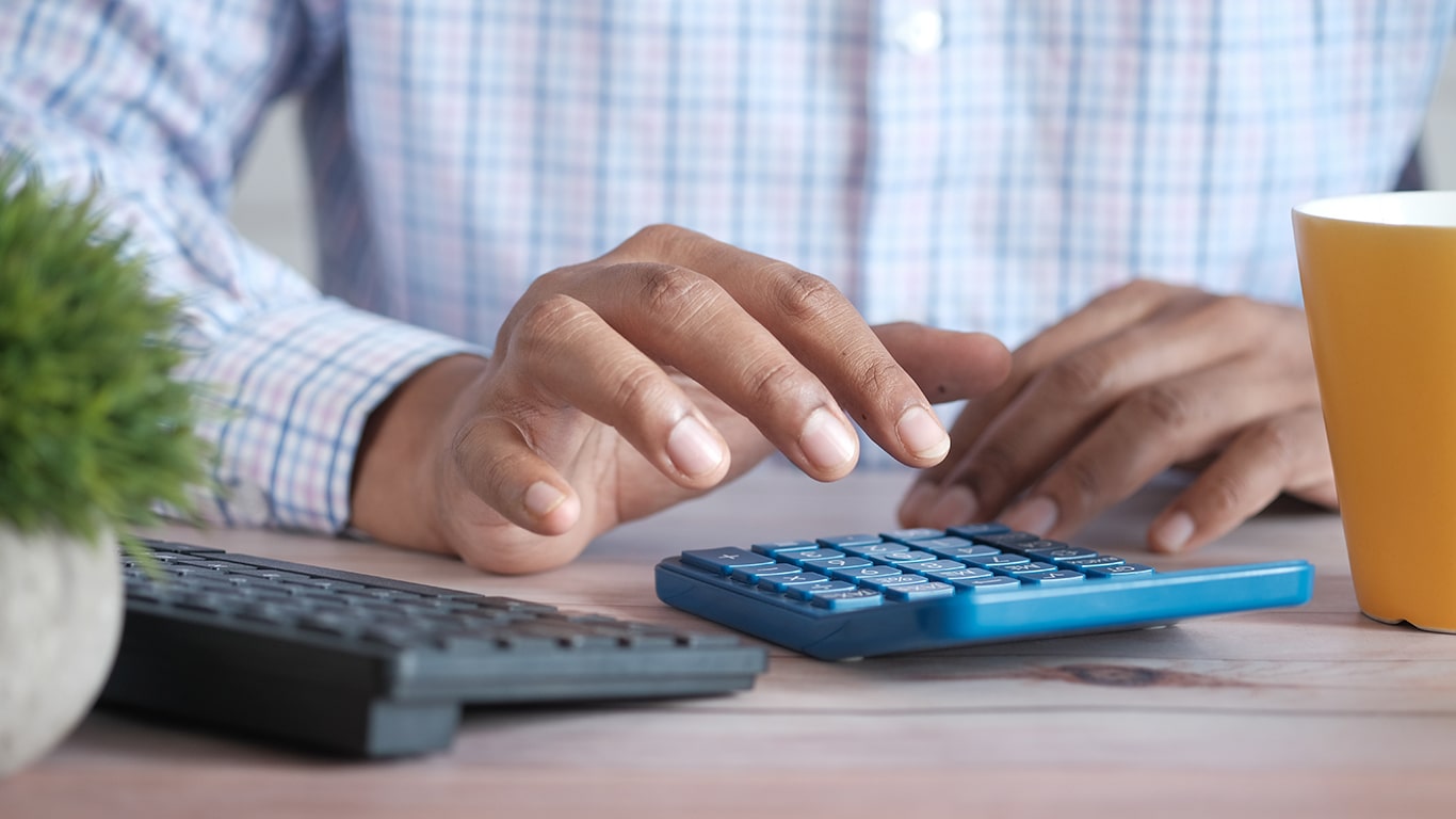 Un homme utilisant une calculette pour calculer les coûts d'un projet européen.